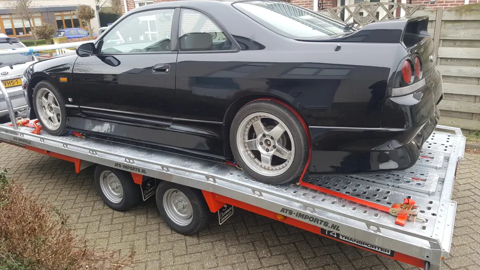 Black Nissan Skyline R33 on a trailer