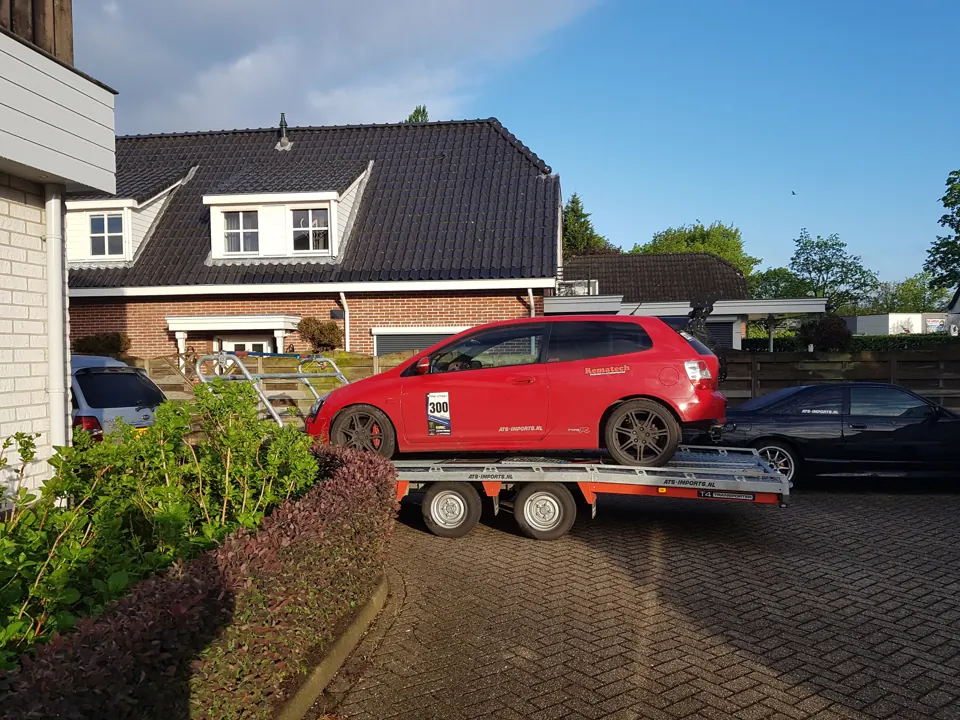 Red hatchback on a trailer