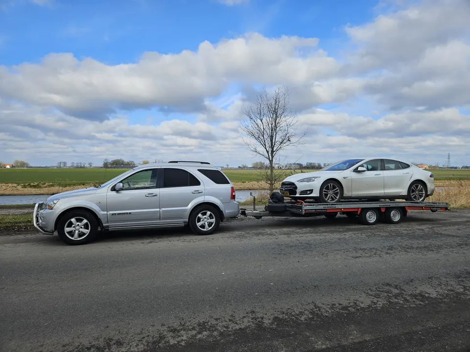 Tow vehicle and sports coupe on a trailer